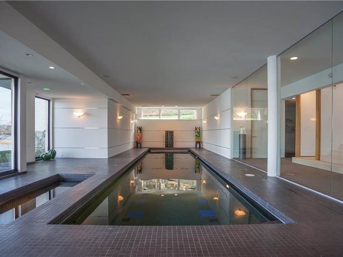 A glass and tile indoor pool on the lower level of the property also looks out toward the lake. Photograph: Hall & Hunter Realtors