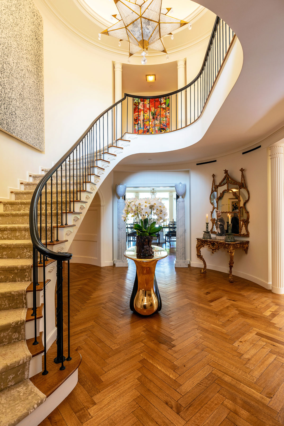 A graceful, curved staircase is the centerpiece of the estate’s entry foyer.