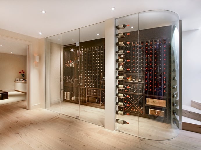 The walk-in, frameless, made-to-order wine pods by Cellar Maison are climate controlled, and can be created with curved or square glass.