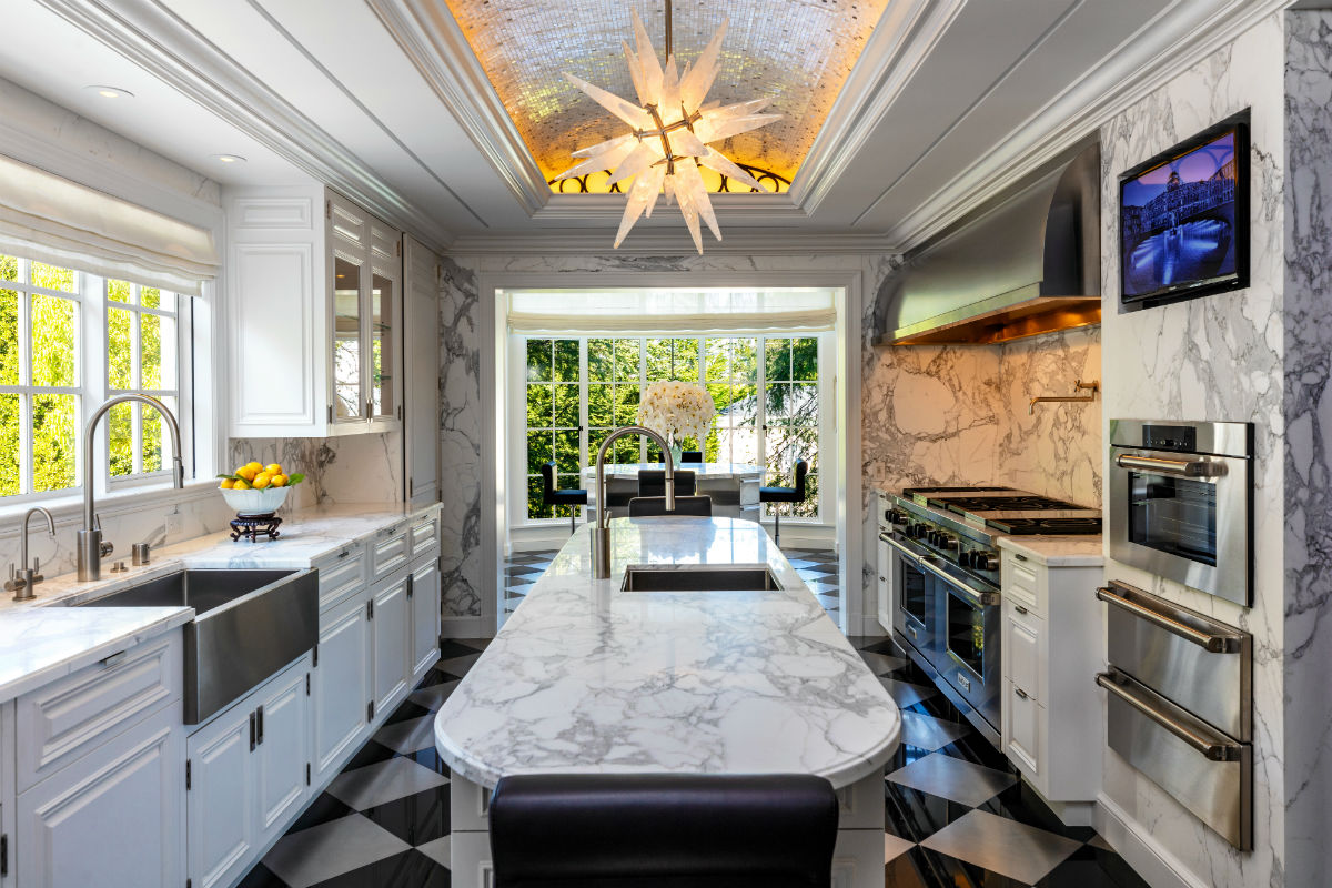An ultramodern kitchen is appointed with state-of-the-art appliances and gleaming marble surfaces.