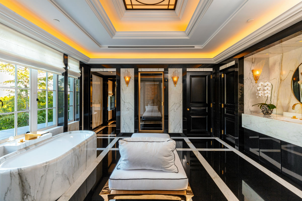 A lavish master bath is resplendent with marble and granite surfaces as well as recessed lighting.