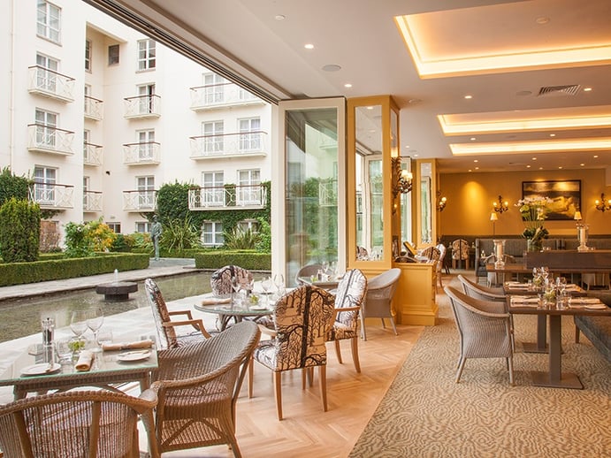 The recently opened Garden Room at The Merrion in Dublin has glass doors that open out onto a courtyard filled with sculpture and decorative fountains.